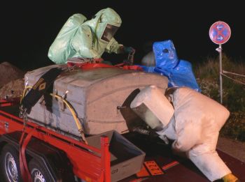 Einsatzkräfte in einem Chemieschutzanzug.