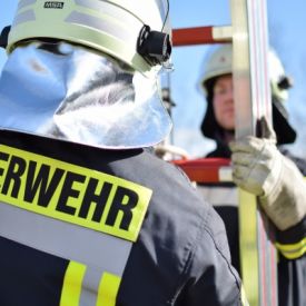 Zwei Feuerwehrangehörige halten eine Leiter