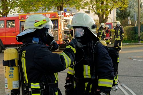 Zwei Atemschutzgeräteträger rüsten sich für den Einsatz aus.