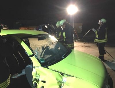 Ein Unfallauto wird mit einer hydraulischen Schere zerschnitten.