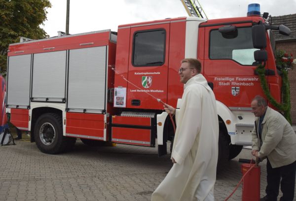 Pastoralreferent Simon Beranek segnet das neue Löschgruppenfahrzeug KatS der Löschgruppe Niederdrees mit Weihwasser aus der Kübelspritze.